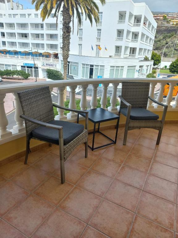 two chairs on a balcony with a view of a building at Club La Mar 62 in Puerto de Santiago
