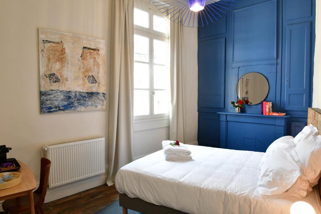 - une chambre bleue avec un lit et une fenêtre dans l'établissement Les Chambres du Cloître, à Limoges