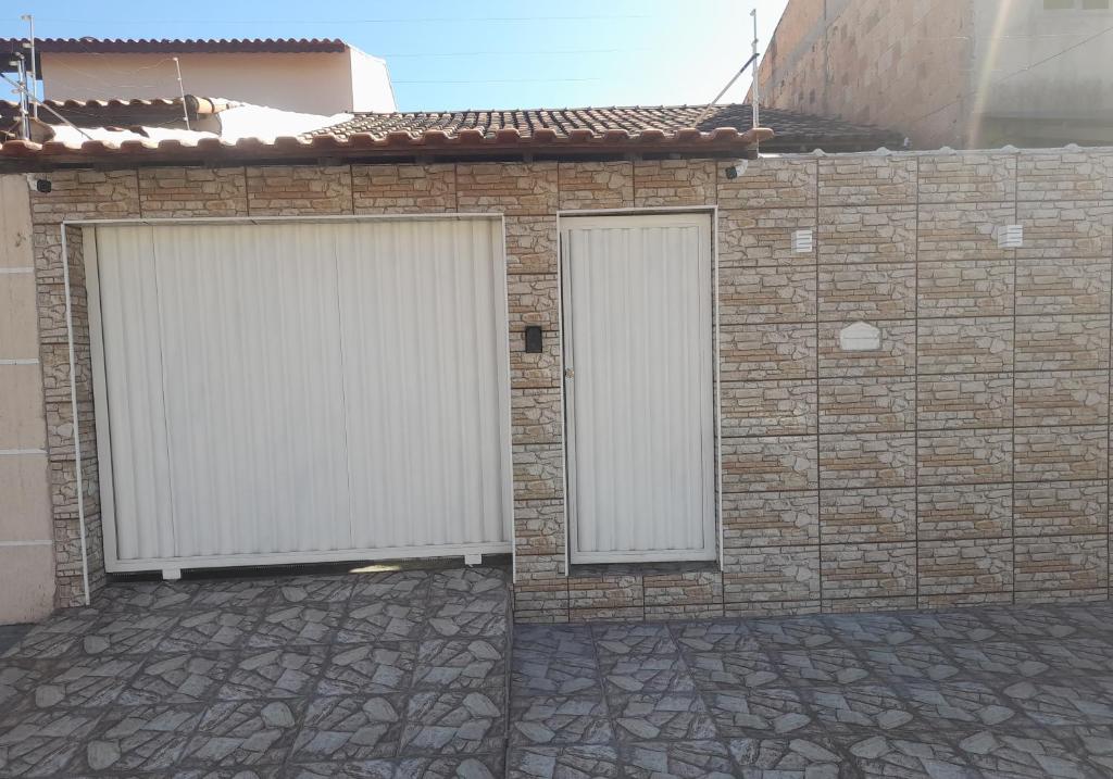 a brick wall with two white gates on it at Junior doce lar in Resende