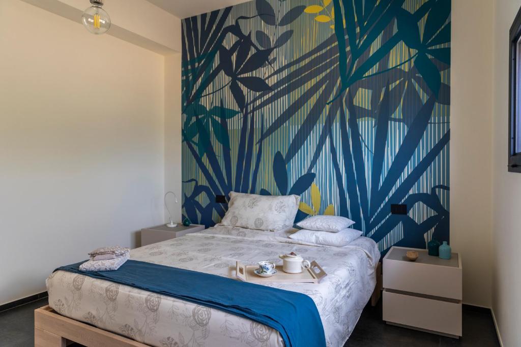 een slaapkamer met een bed met blauw en groen behang bij B&B Coccaluto 39 in Castrignano deʼ Greci