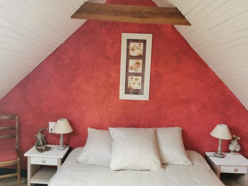 - une chambre dotée d'un mur rouge avec un lit et deux lampes dans l'établissement Les gîtes de Blandine, à Peumérit