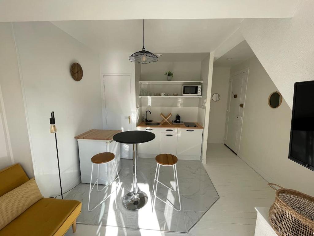 a small kitchen with a table and stools in a room at *Le Baudin : T2 cosy vue dégagée in Limoges