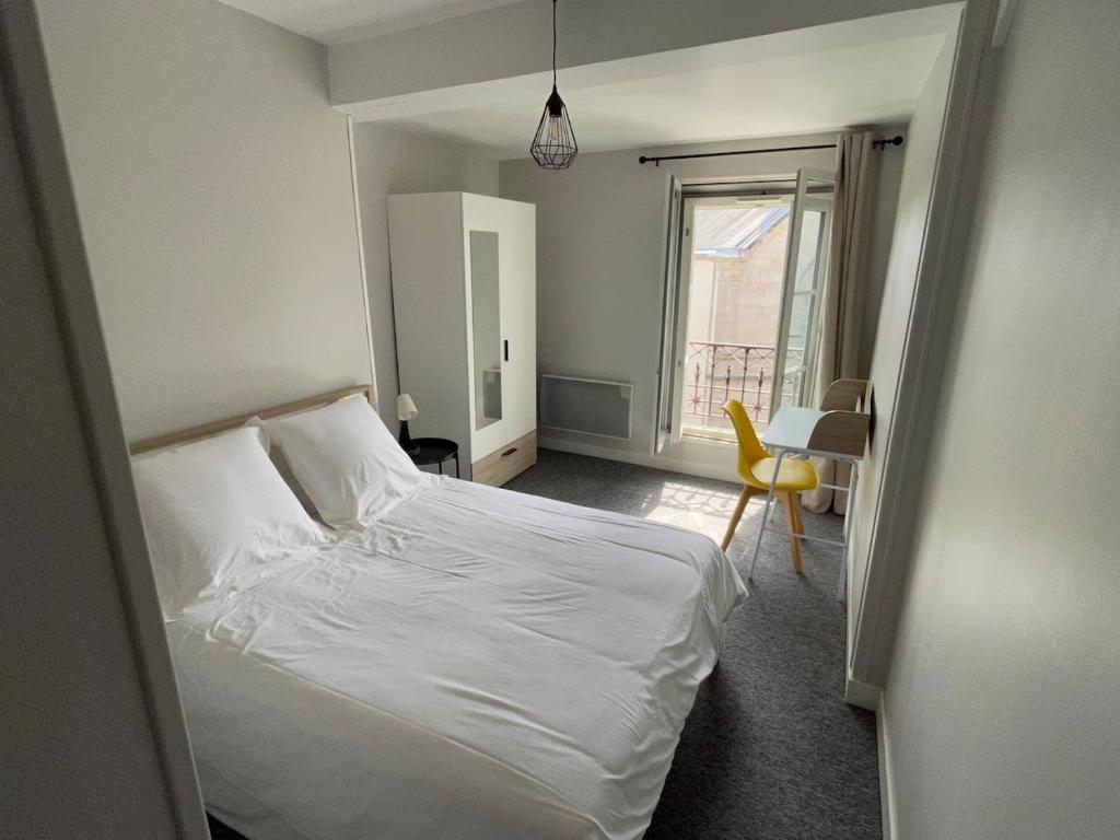 a bedroom with a white bed and a window at *Le Baudin : T2 cosy vue dégagée in Limoges