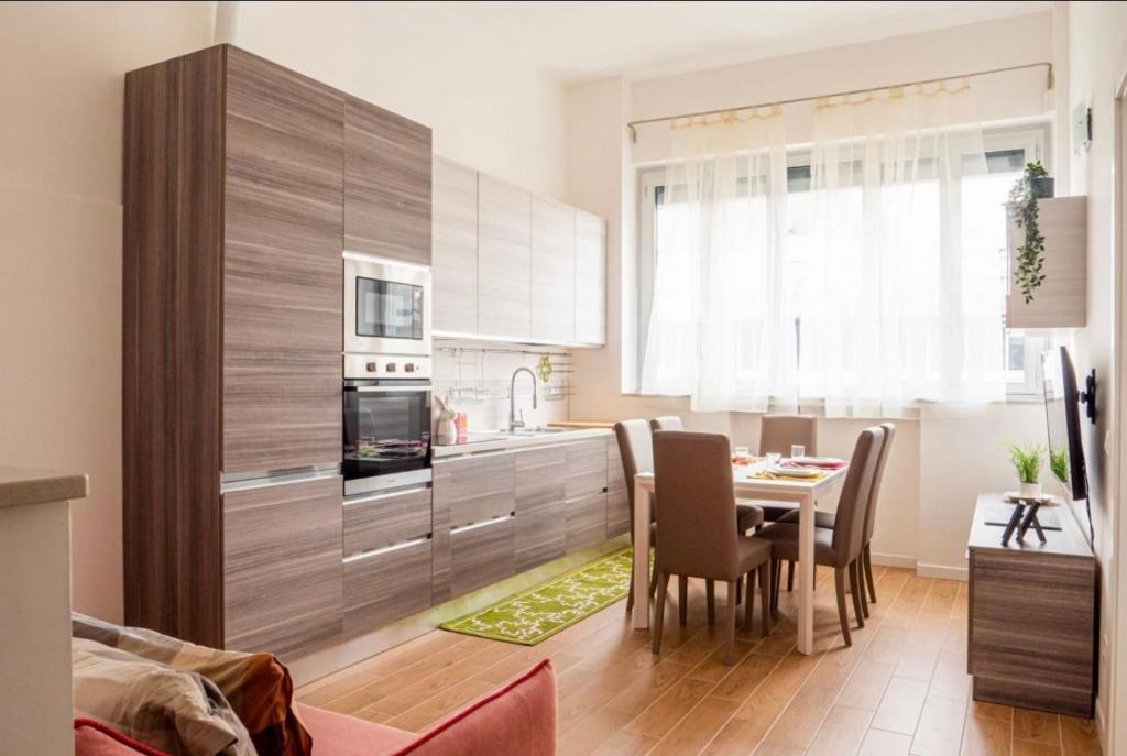 a kitchen with a table and chairs in a kitchen at Vera Project Apartment in Milan