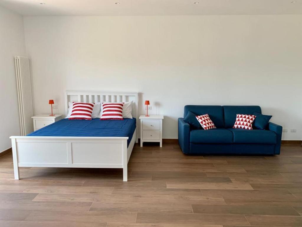 1 dormitorio con 1 cama y 1 sofá azul en Due Golfi Apartment, en SantʼAgata sui Due Golfi