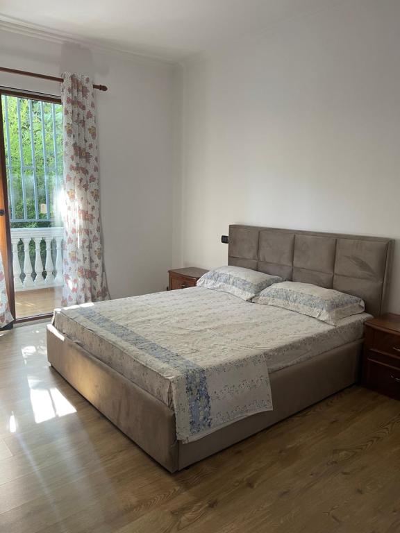 ein Schlafzimmer mit einem Bett und einem großen Fenster in der Unterkunft Ajla’s home in Vorë