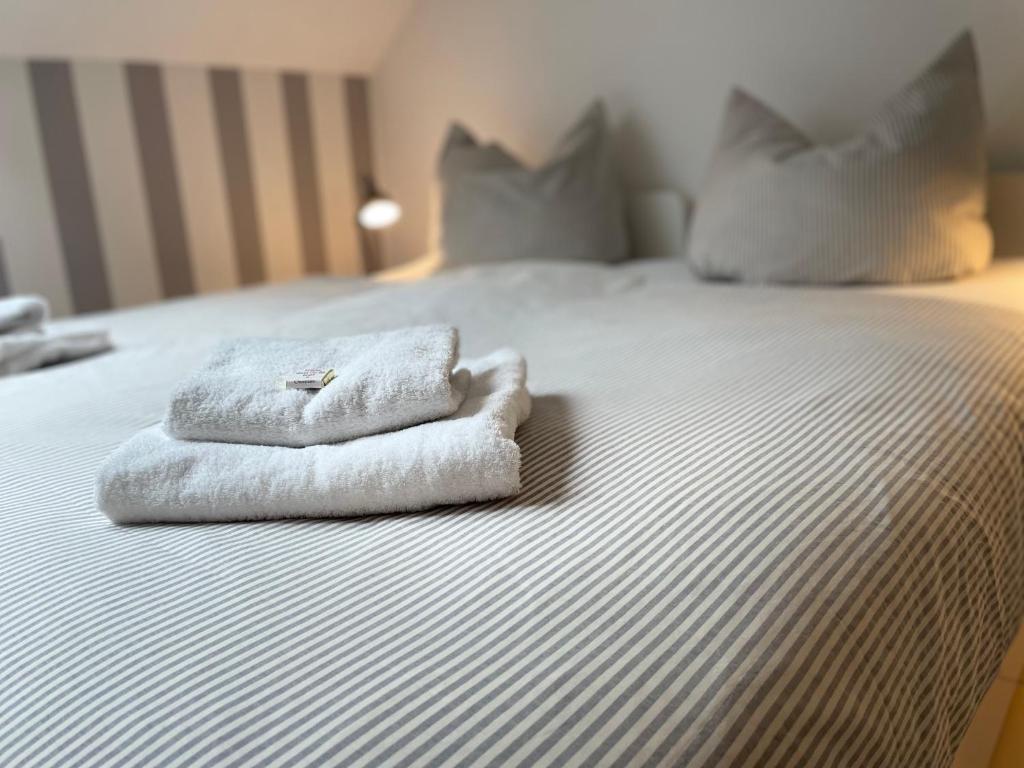 duas toalhas sentadas em cima de uma cama em Weberhof Apartment 5 em Münster