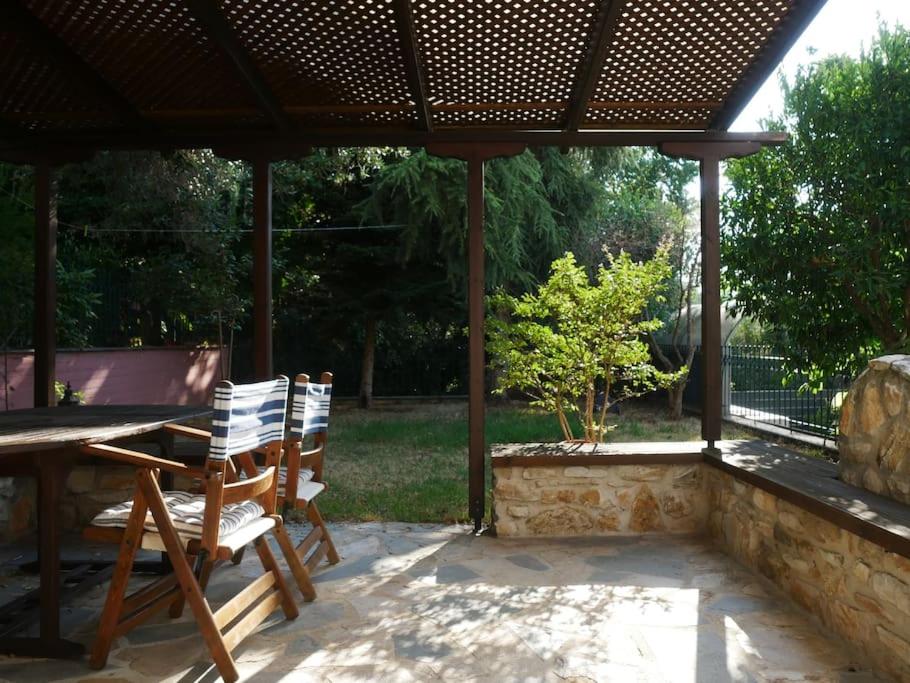 a patio with a table and chairs under a pavilion at Green Cozy Nest in Paleo Tsifliki