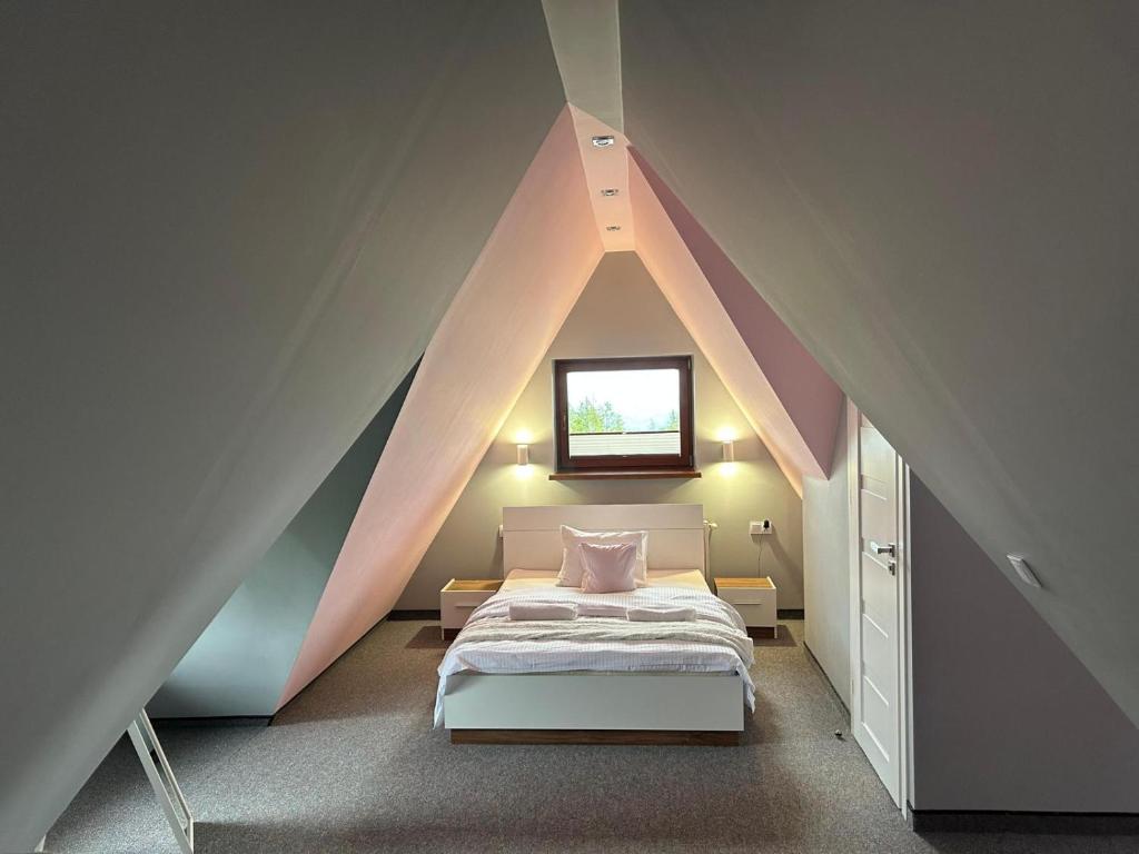 um quarto com uma cama num sótão em Cyrlanka em Zakopane