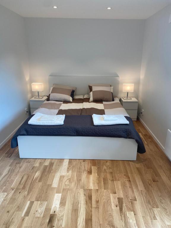 a bedroom with two beds and a wooden floor at Nice guest house in Stockholm