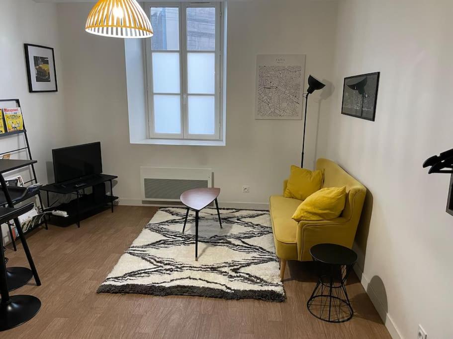 a living room with a yellow chair and a rug at *Le Yellow -Appartement T2, hypercentre* in Limoges