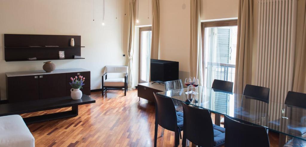 salon ze szklanym stołem i krzesłami w obiekcie Appartamento Sweet Verona w Weronie