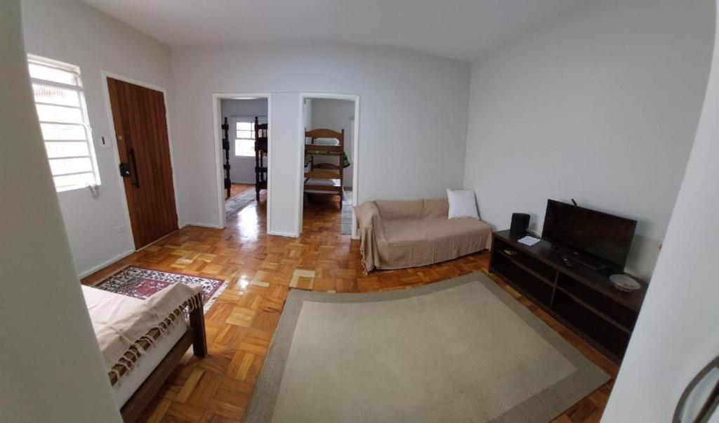 uma sala de estar com um sofá e uma televisão em Hospedagem Franzoi em São Paulo