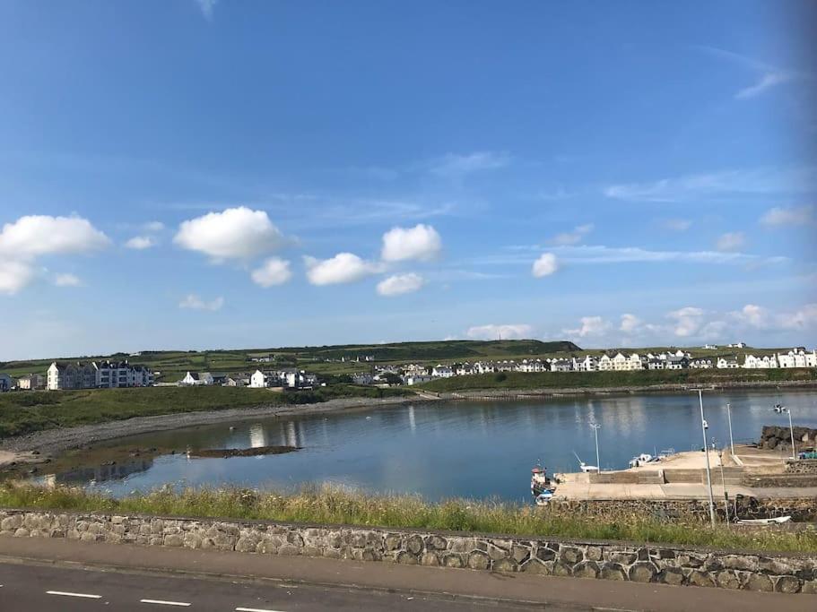 a body of water with a boat in it at Obsidian: Arguably the best view in Portballintrae in Portballintrae