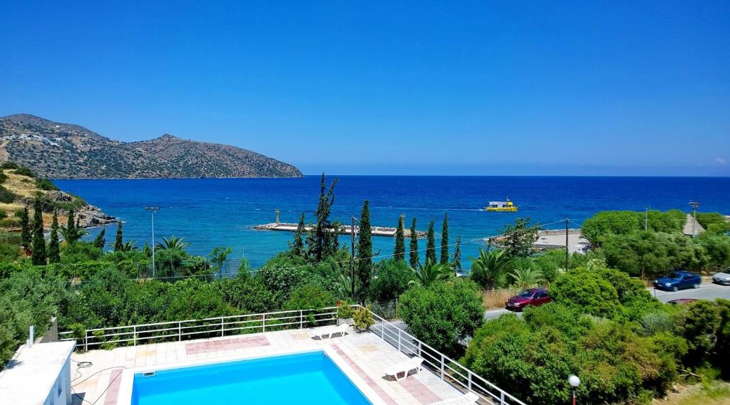 a villa with a swimming pool and a view of the ocean at Dimitra Apartments in Agios Nikolaos