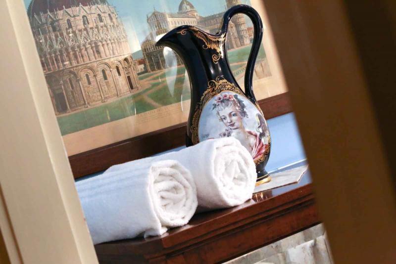 a vase and towels on a shelf with a picture at Casa Esvael Rooms in Verona