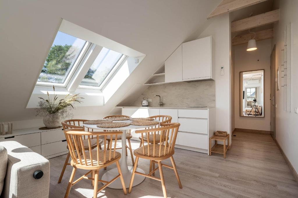 a kitchen and dining room with a table and chairs at Nauji apartamentai! Pamario 14 in Nida