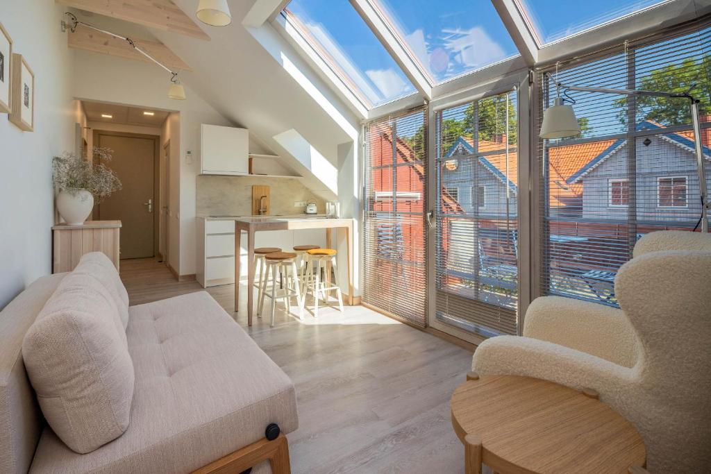 a living room with a couch and a large window at Nauji apartamentai! Pamario 14 in Nida