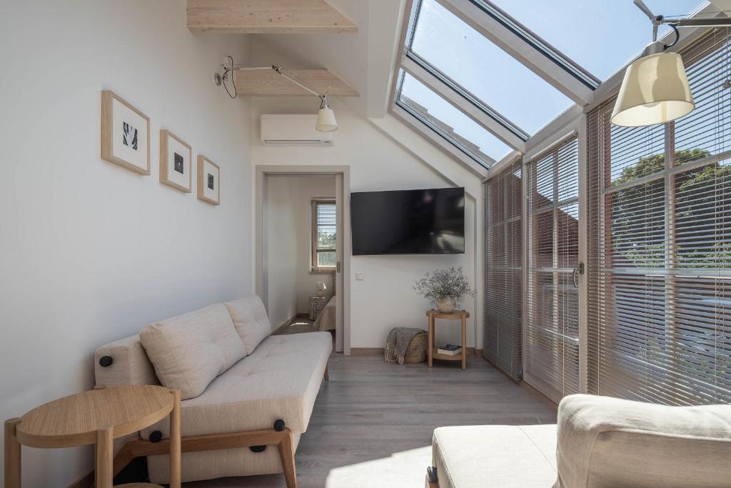 a living room with a couch and a tv at Nauji apartamentai! Pamario 14 in Nida