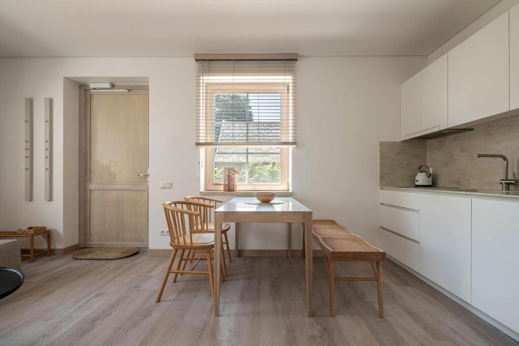 a kitchen with a table and chairs in a room at Nauji apartamentai! Pamario 14 in Nida