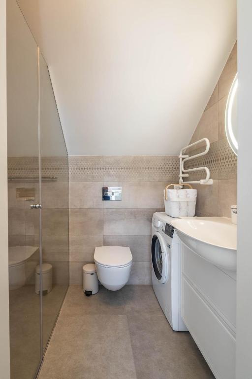 a bathroom with a washing machine and a sink at Nauji apartamentai! Pamario 14 in Nida