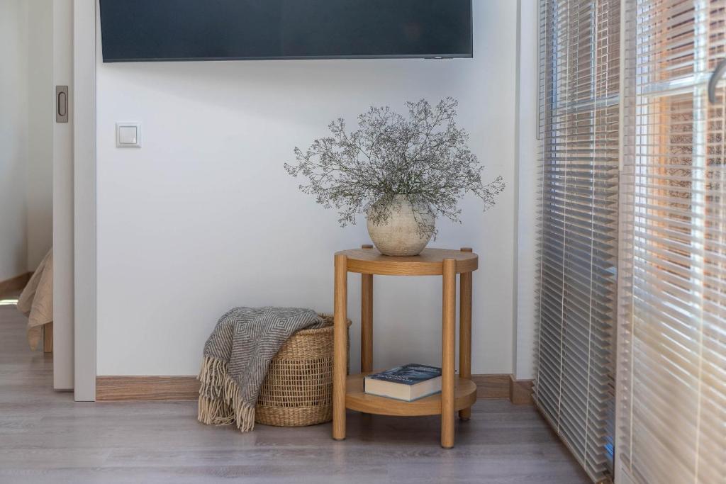 a plant in a vase on a table in a room at Nauji apartamentai! Pamario 14 in Nida