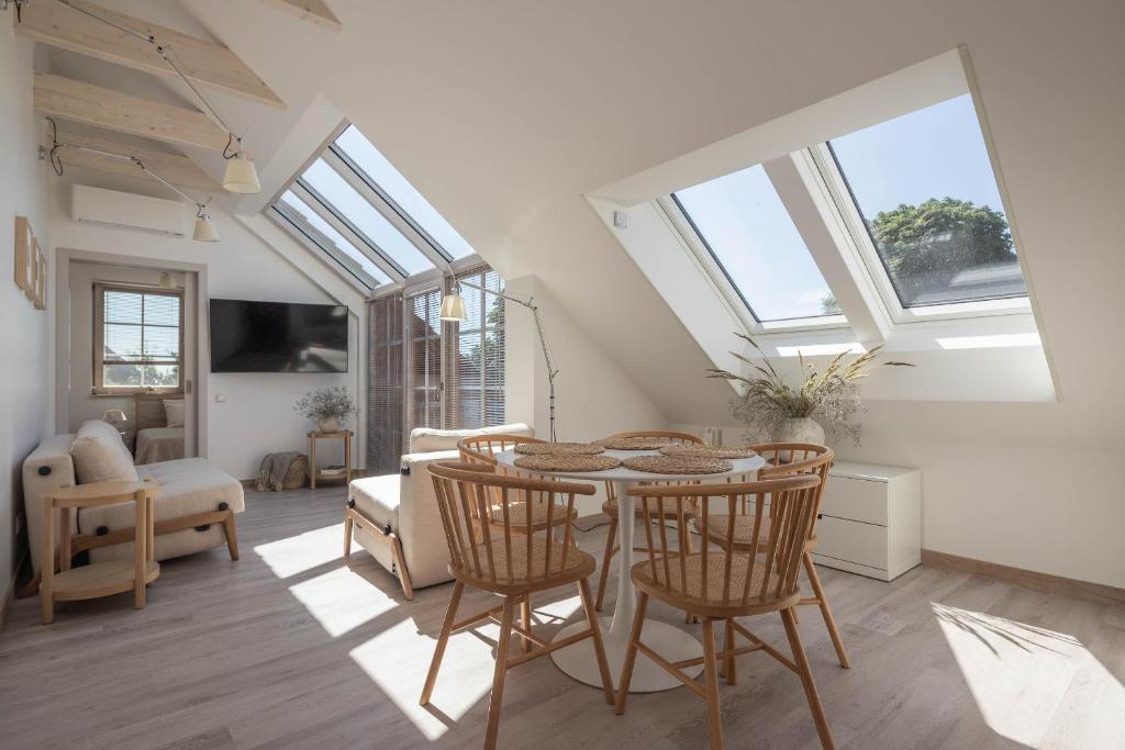 a living room with a table and some windows at Nauji apartamentai! Pamario 14 in Nida