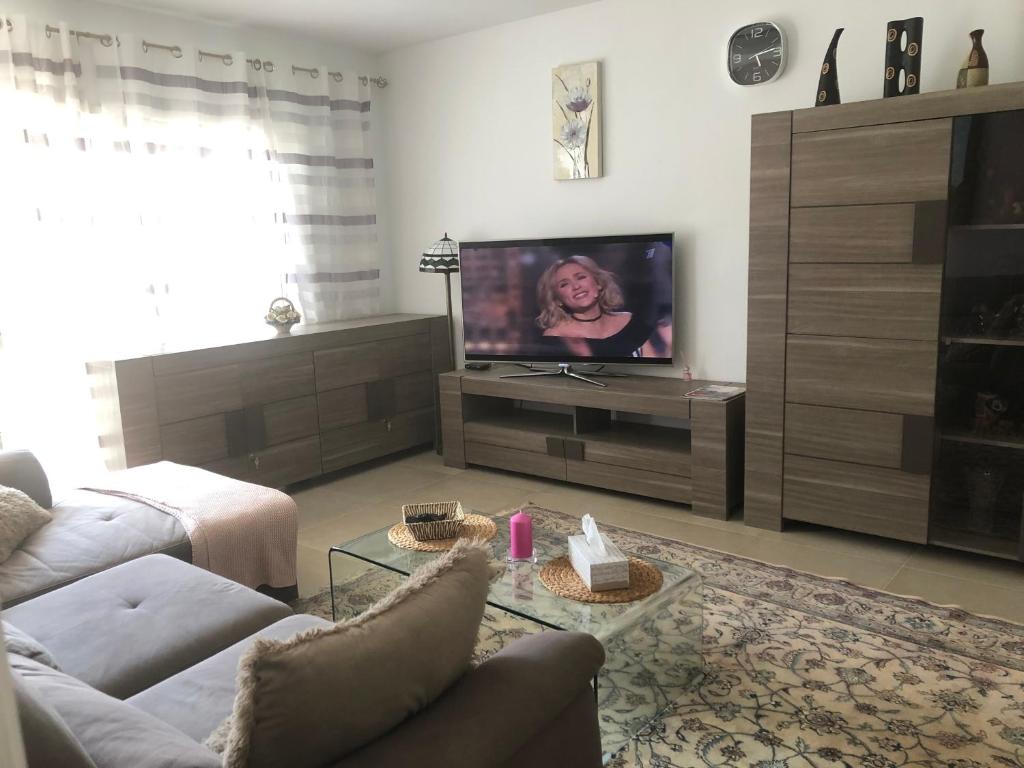 a living room with a couch and a flat screen tv at Bouganvilla in Adeje