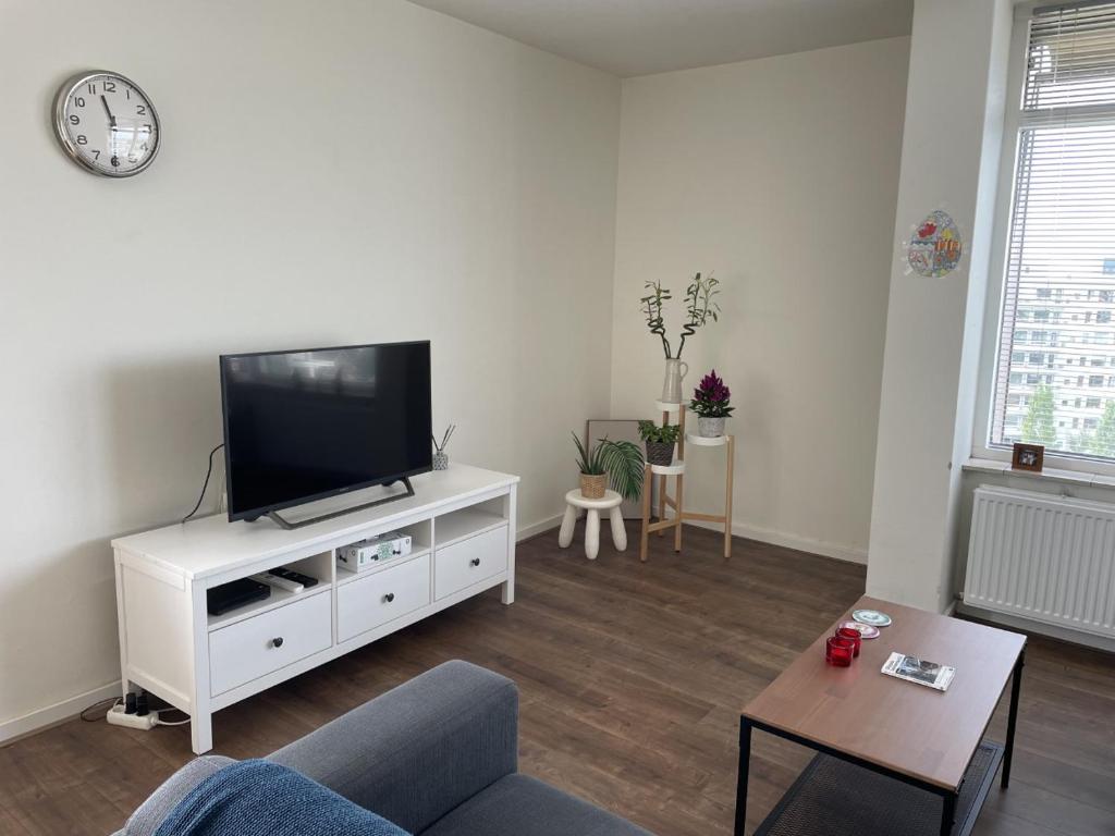 ein Wohnzimmer mit einem Flachbild-TV auf einem weißen Schrank in der Unterkunft Apartment with city skyline in Leeuwarden