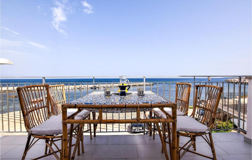 d'une table et de chaises sur un balcon donnant sur l'océan. dans l'établissement Amazing Home In Trappeto With Wifi, à Trappeto