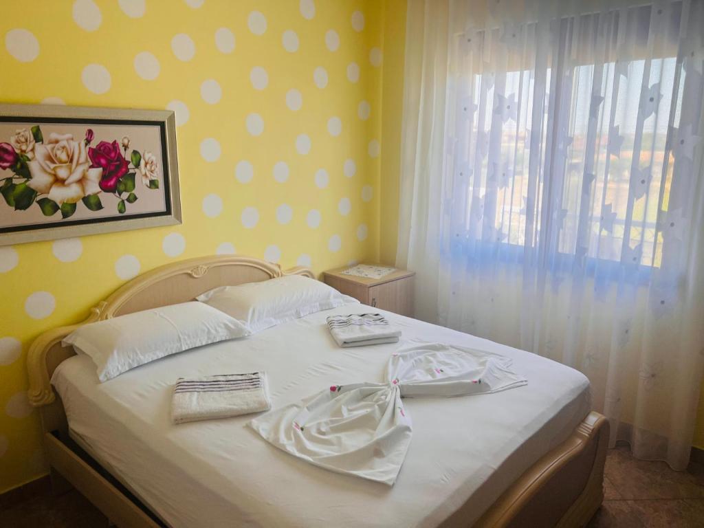 una camera da letto con un letto con lenzuola bianche e una finestra di Fori Vodo a Divjakë