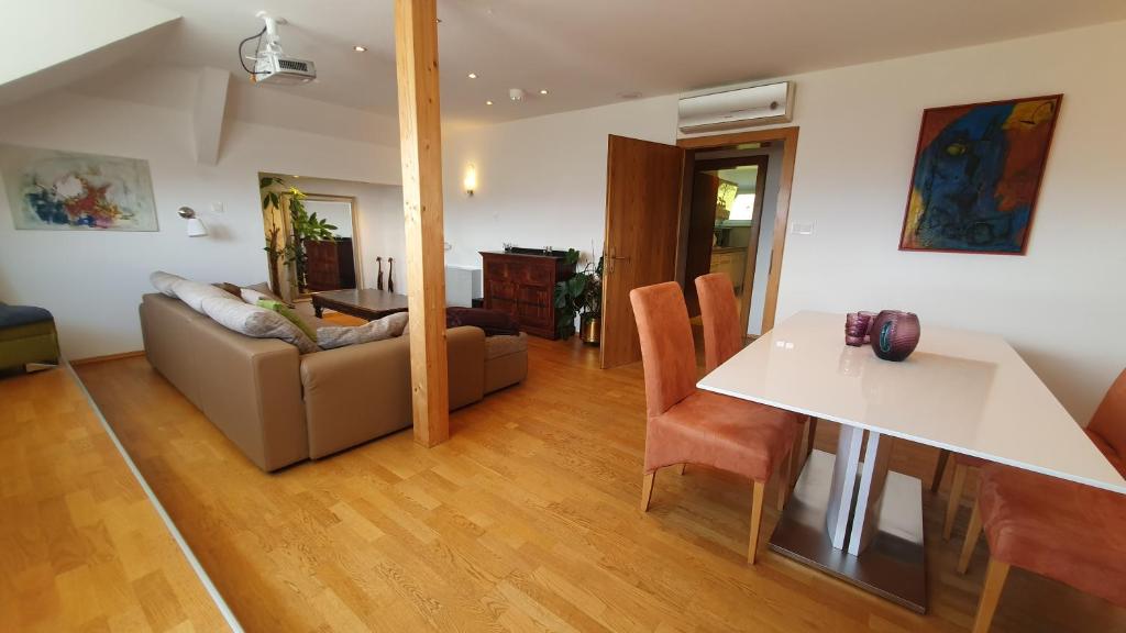 uma sala de estar com um sofá e uma mesa em Lakeside Hills Apartment, Appartement em Krumpendorf am Wörthersee