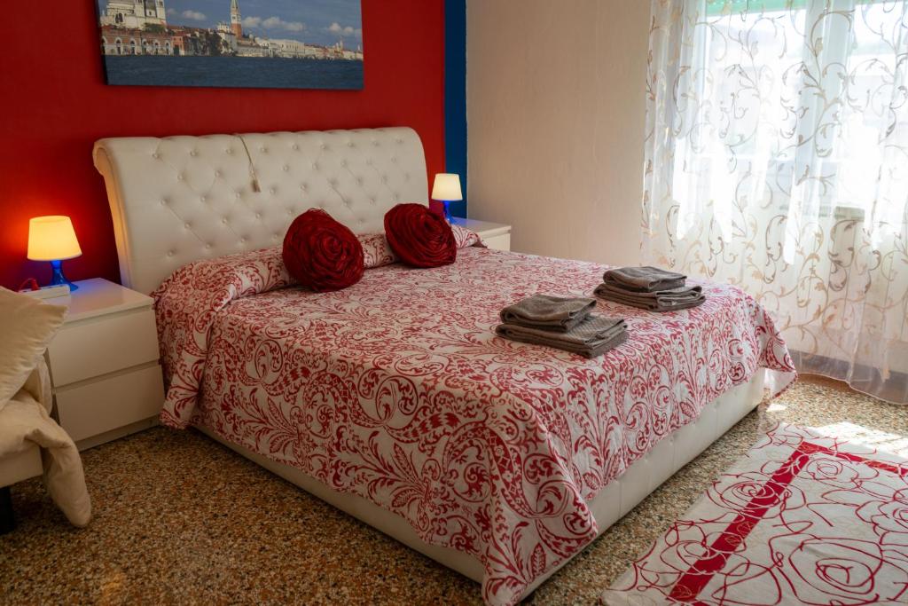 メストレにあるホリデイ ウィズ チルドレン イン ヴェニスのベッドルーム1室(赤いシーツと赤い枕のベッド1台付)