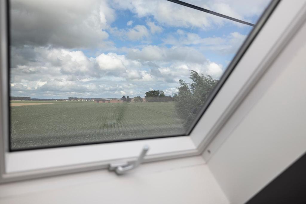 a window with a view of a green field at Vakantiehuis Paula in Watervliet