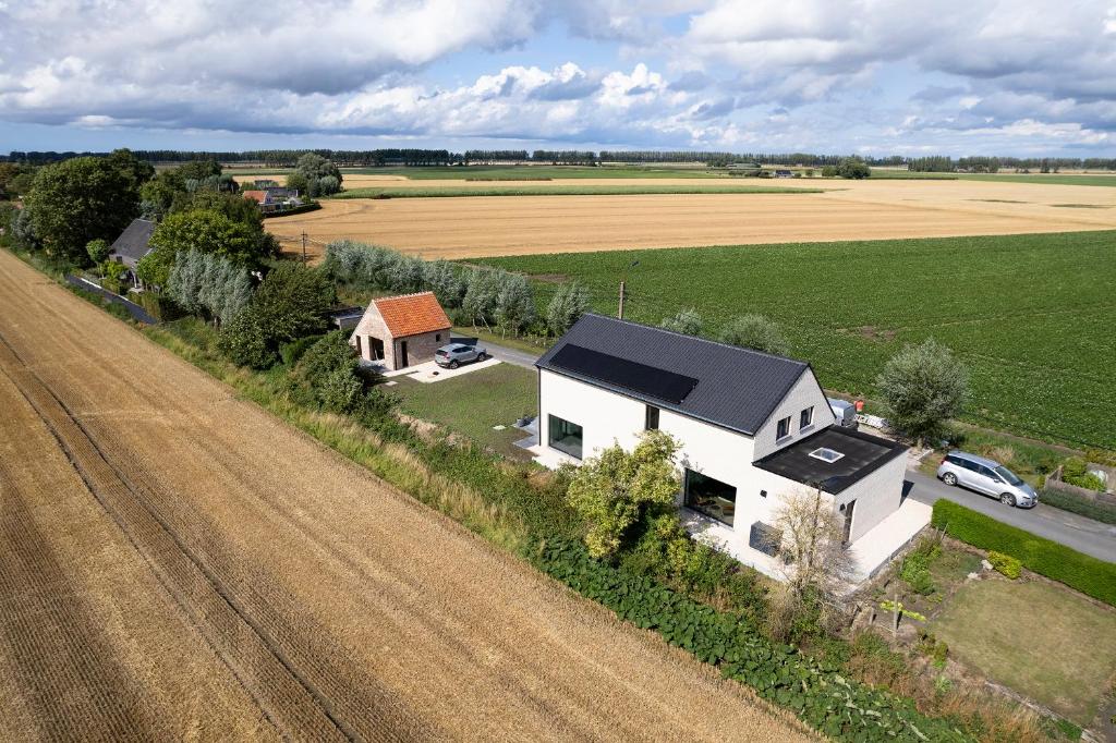 an aerial view of a white house and a field at Vakantiehuis Paula in Watervliet