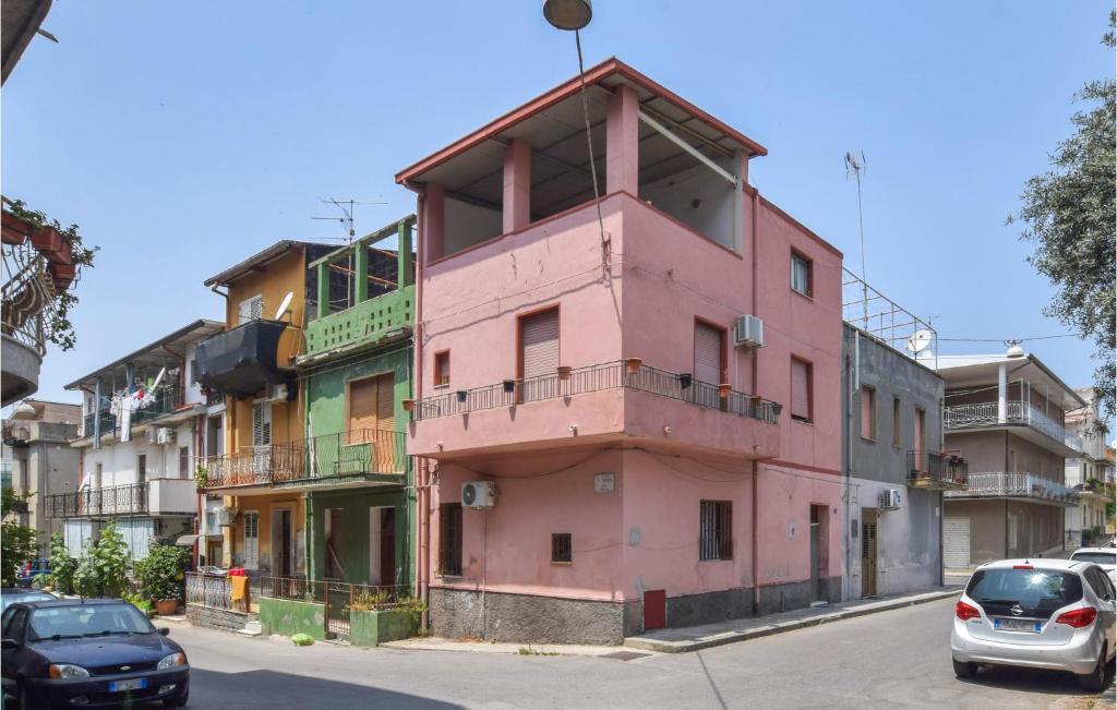 un bâtiment rose sur le côté d'une rue dans l'établissement Beautiful Home In Bova Marina With 1 Bedrooms, à Bova Marina