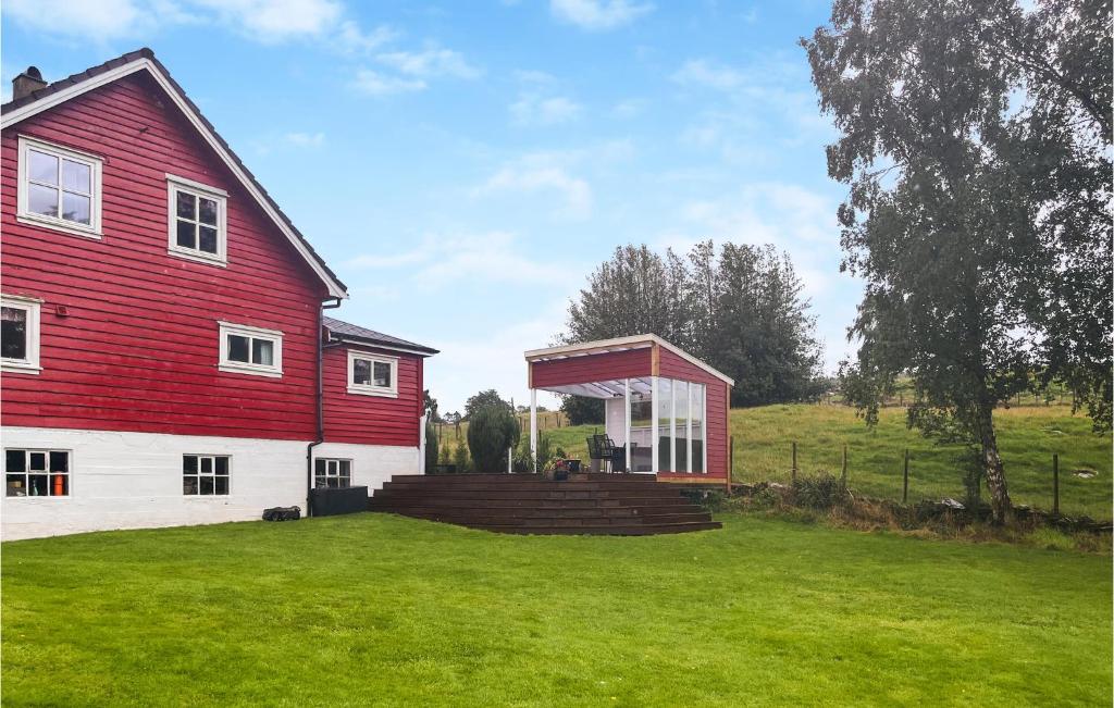 a red and white house with a large yard at Beautiful Home In Sjernary With House Sea View in Nedstrand