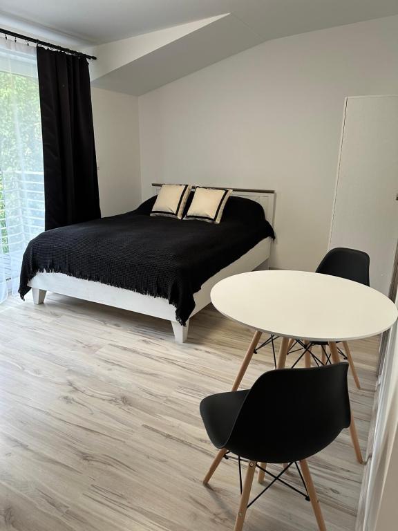 um quarto com uma cama, uma mesa e cadeiras em Roomflacja em Wisla