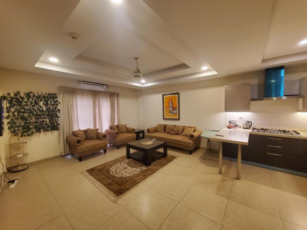 a kitchen and a living room with a table and chairs at Private 1-Bedroom Apartment in Rawalpindi