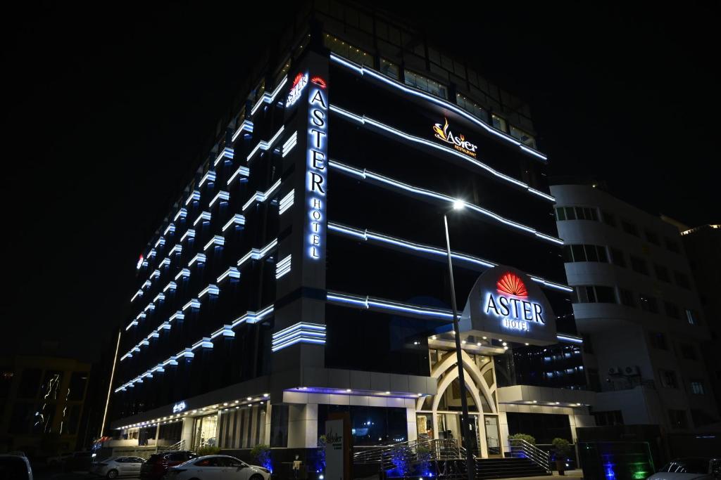ジッダにあるAster Hotelの夜間の看板付きの建物