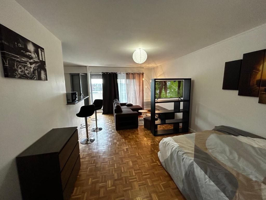 une chambre avec un lit et un salon dans l'établissement Bel appart de 45m2 à courbevoie, à Courbevoie