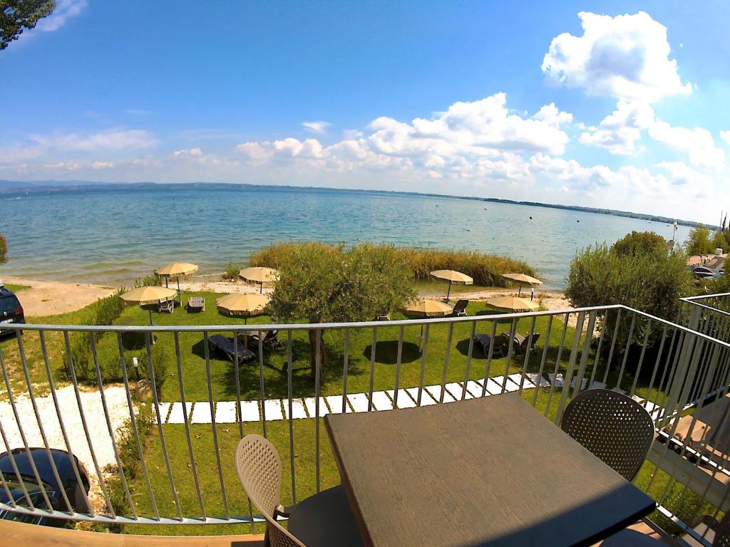einen Balkon mit einem Tisch und Meerblick in der Unterkunft Smeraldo dip Villa Canneto in Sirmione