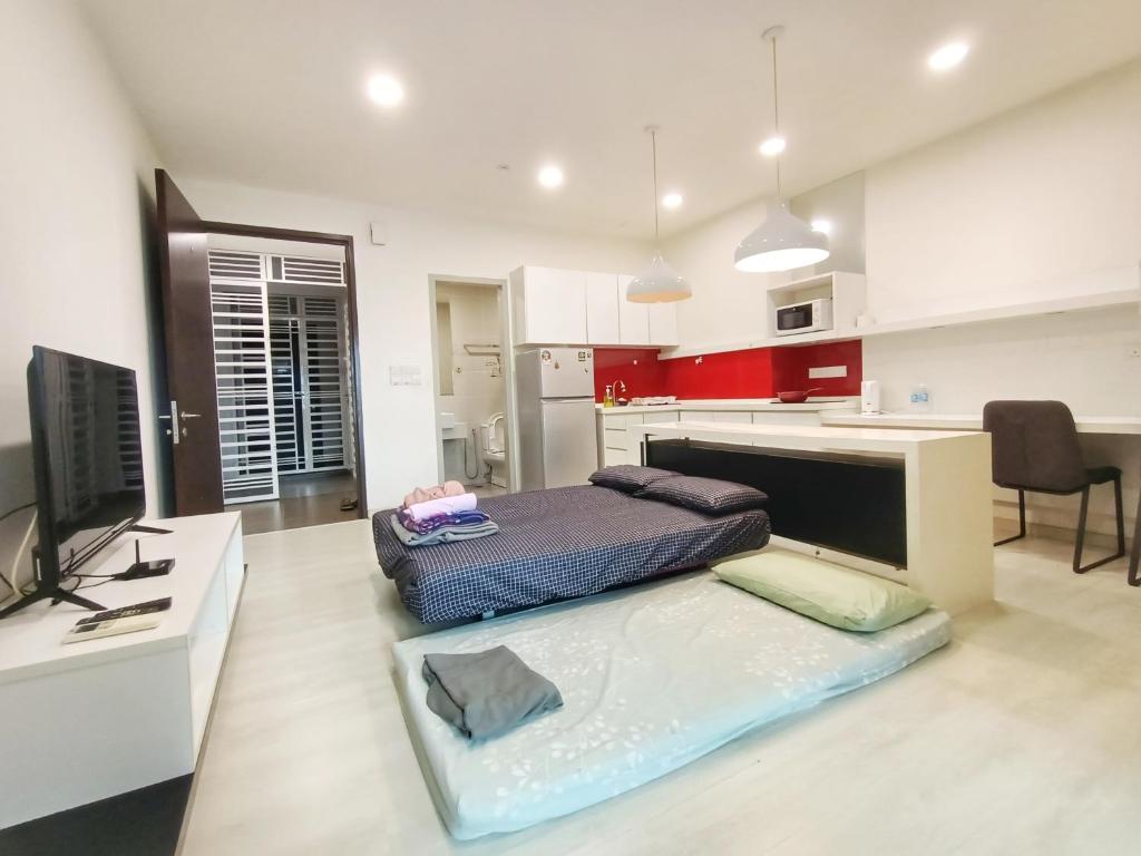 a living room with a bed and a kitchen at Deluxe Suites 4, 2-5 pax, Netflix, Georgetown in Jelutong