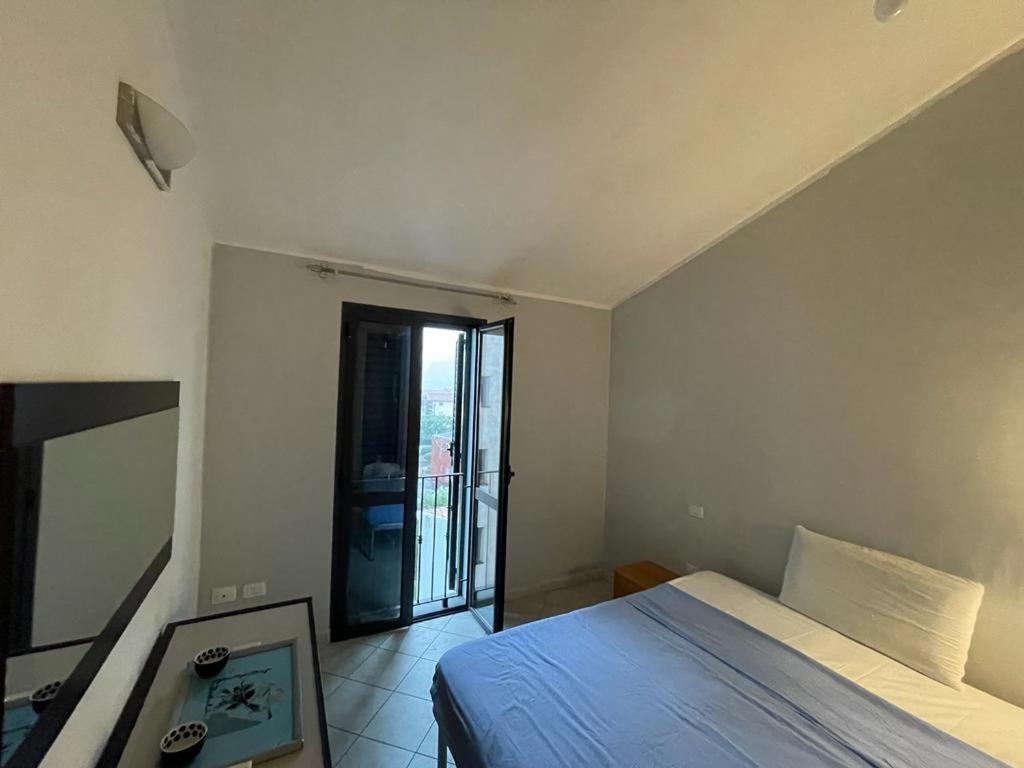 a bedroom with a bed and a door to a balcony at Appartamento al mare in Bosa Marina