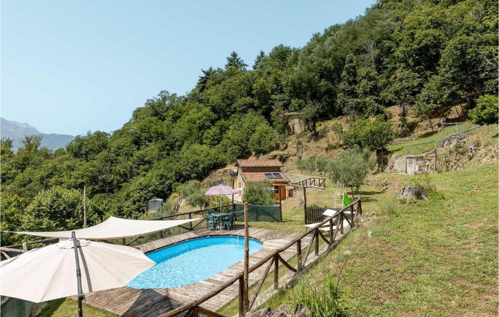- une piscine avec un parasol à côté d'une colline dans l'établissement Cozy Home In Barga With Wifi, à Barga