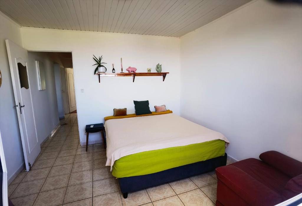 sypialnia z łóżkiem w pokoju z kanapą w obiekcie La case ludovic w mieście Le Tampon
