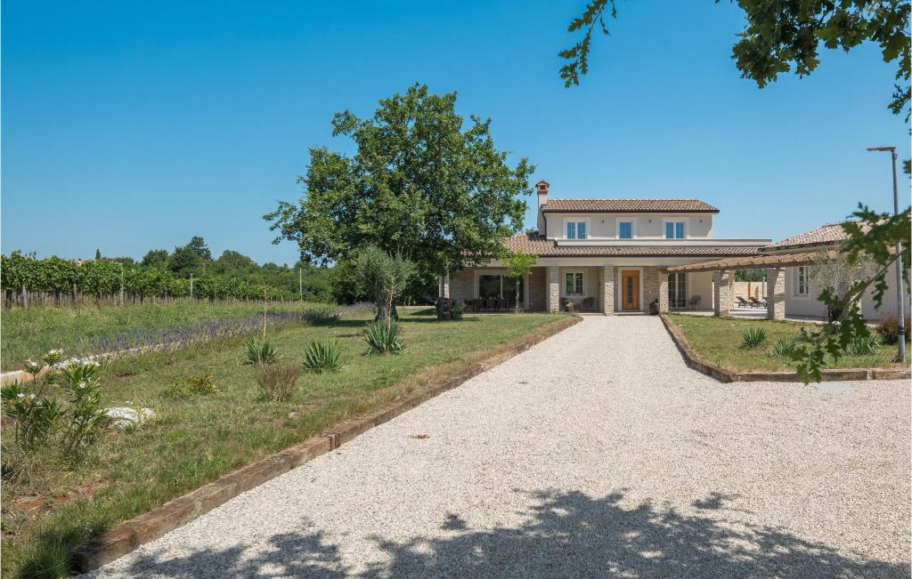 a house with a driveway in front of a vineyard at 3 Bedroom Cozy Home In Buje in Buje