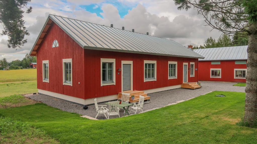 een rode schuur met een picknicktafel ervoor bij Lillstugans Gästhem BnB in Vöyri