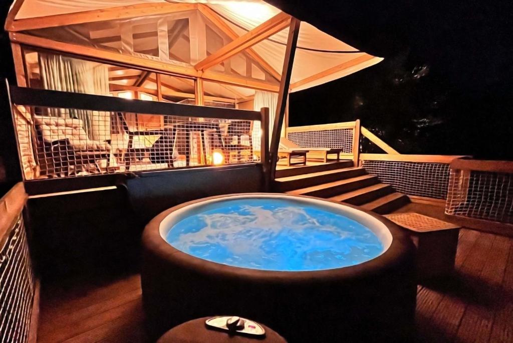 un jacuzzi en la terraza de una casa en Glamping - Il Giardino di San Giorgio, en Montorgiali