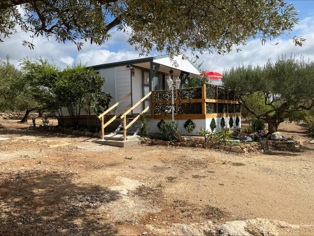 a small white house with a porch and trees at Chalet Espagne EL FARO 4/6p in Camarles